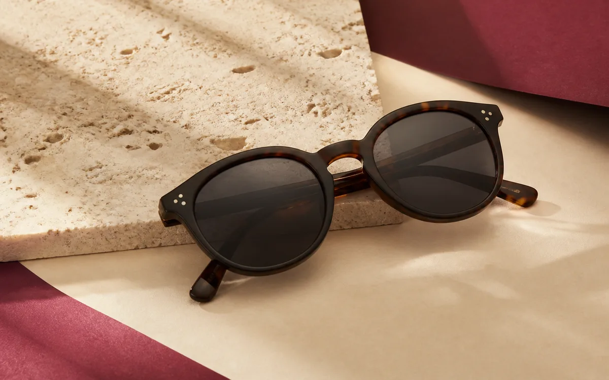 Lentes de sol presentados sobre materiales naturales